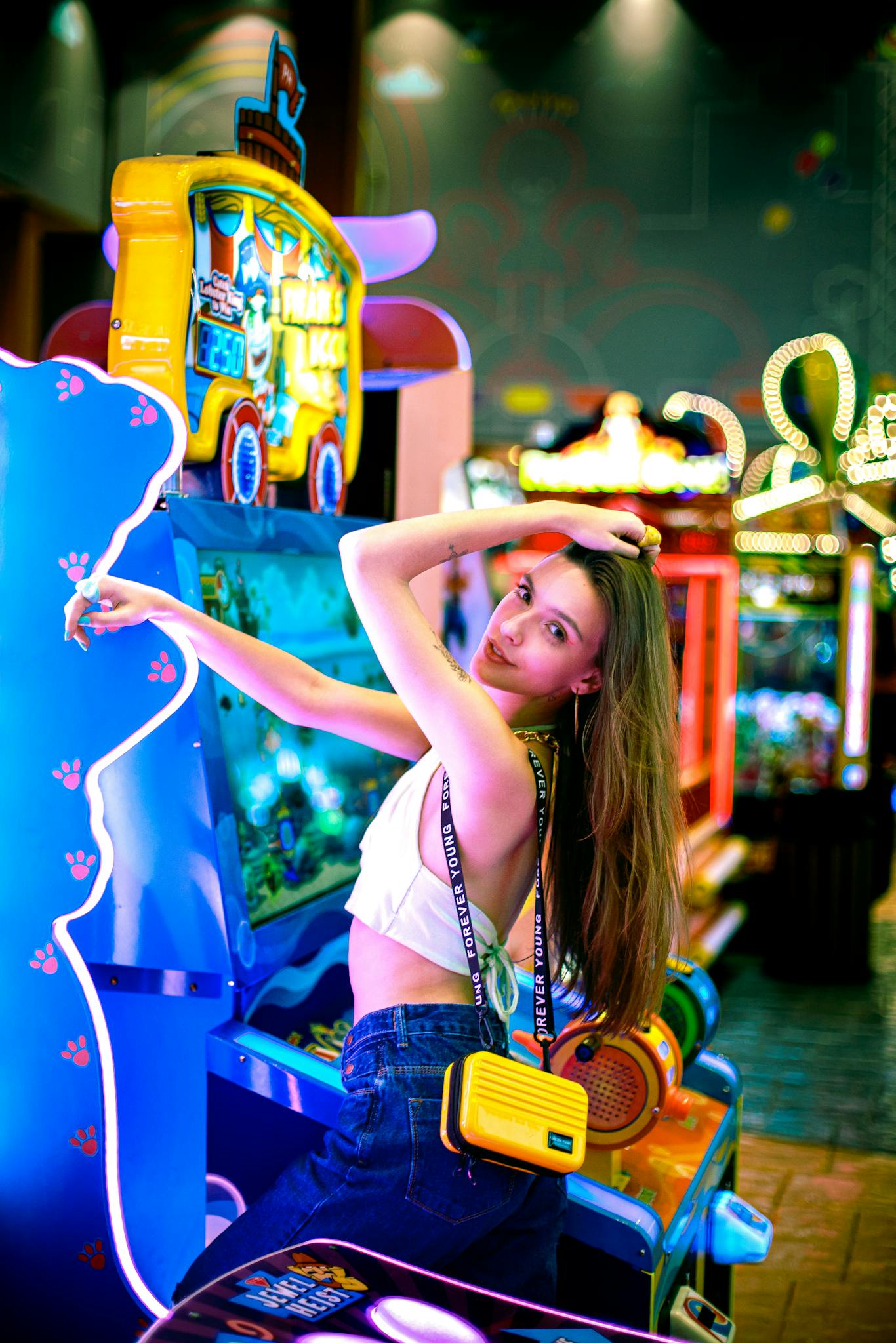 A vibrant scene of a young woman having fun at a neon-lit arcade.
