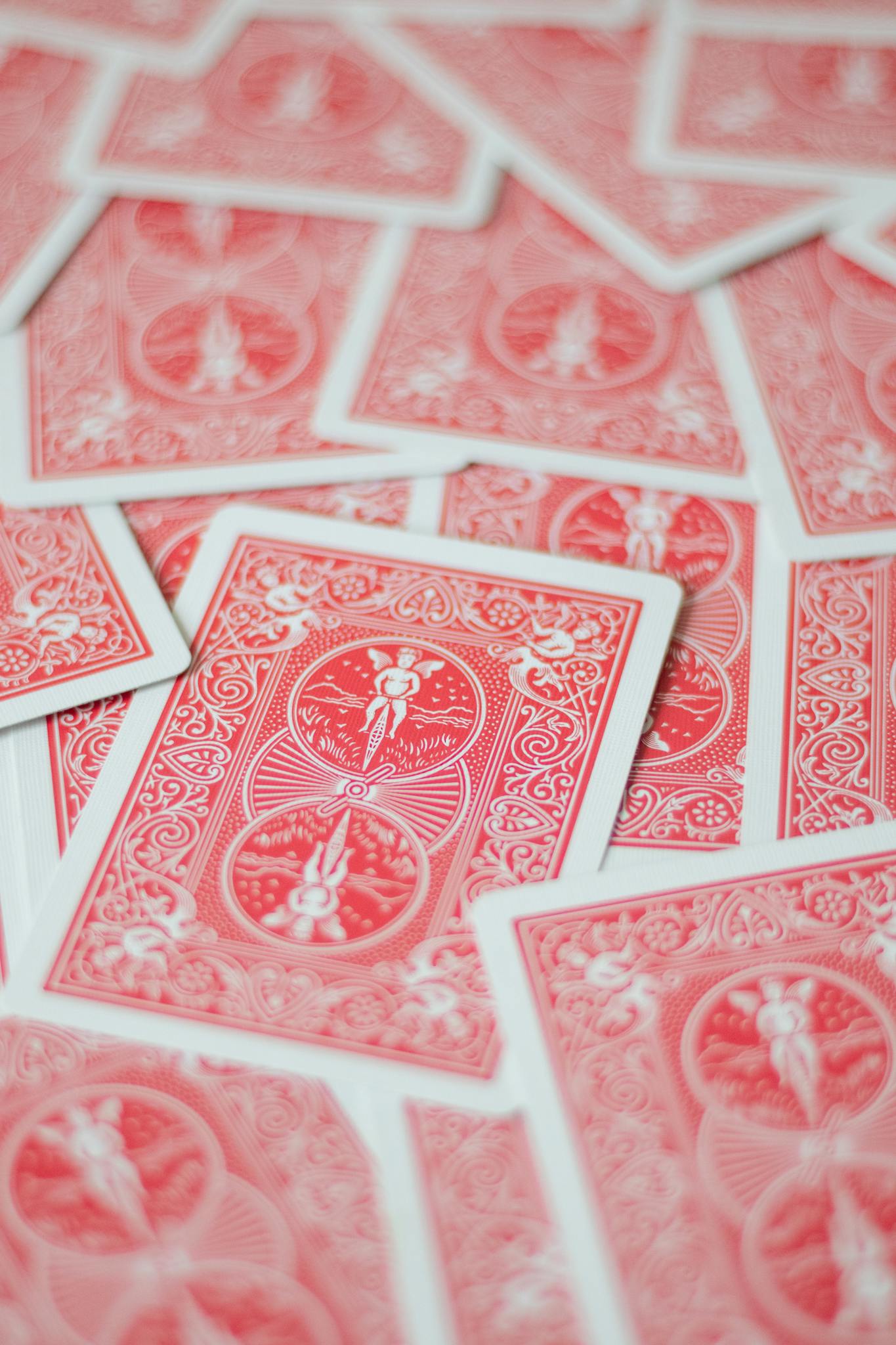 Vibrant red playing cards scattered in an artistic arrangement, showcasing design.
